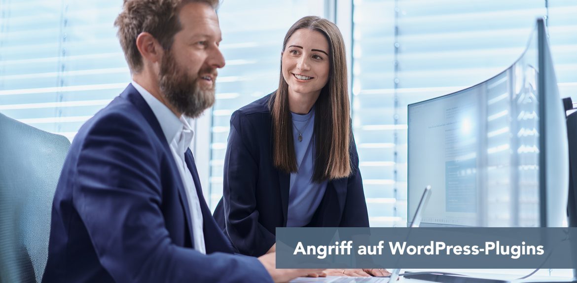 Zwei Kollegen im Büro schauen auf einen Monitor; Text im Bild: Angriff auf WordPress-Plug-ins.