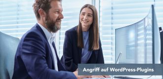 Zwei Kollegen im Büro schauen auf einen Monitor; Text im Bild: Angriff auf WordPress-Plug-ins.